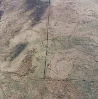 Oblique aerial view centred on the remains of the fort and palisaded enclosure with field-system, rig, boundary banks, enclosures and lazy beds adjacent, taken from the SW.
