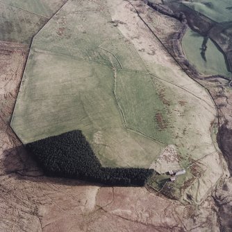 Oblique aerial view centred on the remains of the field-system, lazy-beds and cottage, taken from the NNW.