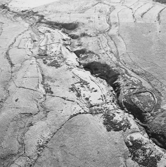 Oblique aerial view of Thief Sike centred on the remains of a township, field-system, rig, quarry and pens with a possible hut-circle, cultivation terraces, small cairns and shieling huts and a possible sheepfold adjacent, taken from the N.