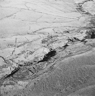 Oblique aerial view of Thief Sike centred on the remains of a township, field-system, rig, quarry and pens with a possible sheepfold adjacent, taken from the WNW.
