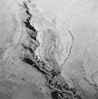 Oblique aerial view of Thief Sike centred on the remains of a township, field-system, rig, quarry and pens with a possible hut-circle, cultivation terraces, small cairns and shieling huts and a possible sheepfold adjacent, taken from the S.