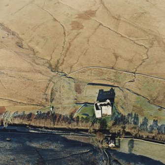 Oblique aerial view of Hermitage Castle centred on the remains of a castle and earthwork castle, taken from the S.