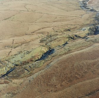 Oblique aerial view of Thief Sike centred on the remains of a township, field-system, rig, quarry and pen with the remains of a possible sheepfold adjacent, taken from the WNW.