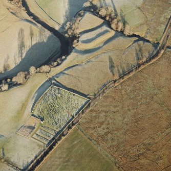Oblique aerial view of Castleton centred on a burial-ground and remains of an earthwork fortification, from SW.