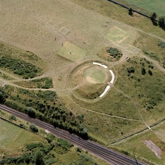 Oblique aerial view of the remains of Muir of Ord henge, Castle Hill.