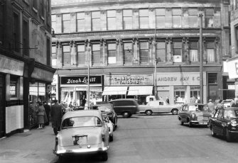 Glasgow, Cowcaddens Cross.
Detail of three shops on Cowcaddens Street.
Shops seen are; Andrew Hay and Co. (no.112), Caledonian Taylors (no.114), Dinah Lovitt (no.118).