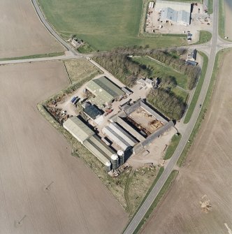 Oblique aerial view centred on the farmsteading, manse and walled garden, with the church, churchyard and war memorial adjacent, taken from the SSW.