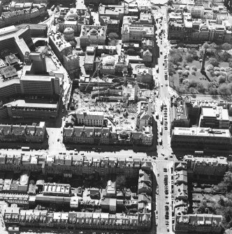 Oblique aerial view centred on the construction of the shop and bus station with the bank adjacent, taken from the N.