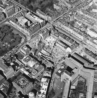 Oblique aerial view centred on the construction of the shop and bus station with the bank adjacent, taken from the ESE.