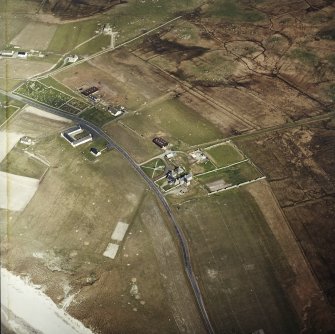 Oblique aerial view centred on the farmhouse, with the farmstead, the farmsteading and the burial enclosures adjacent, taken from the WSW