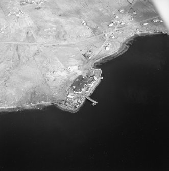 Oblique aerial view centred on the factory and laboratory with the pier and remains of lazy beds adjacent, taken from the WSW.