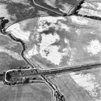 Drumrosach, oblique aerial view, taken from the SW, centred on the cropmarks of a ring-ditch and two pit-circles.