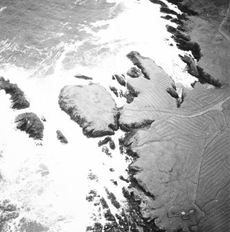 Oblique aerial view centred on the remains of the settlement with the remains of lazy beds adjacent, taken from the NW.