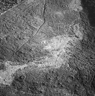 Tormore, oblique aerial view, taken from the NW, centred on a hut-circle. Further hut-circles are visible in the top centre and bottom left-hand corner of the photograph.