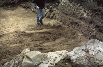 Photograph taken during the Council for British Archaeology 1987 Summer School. Working shot of the excavations, including the excavation of a skeleton.