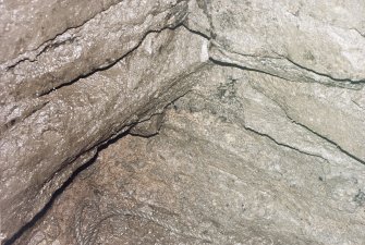 Detail of junction of slabs forming floor of cistern and walling showing bones and smears of charcoal.