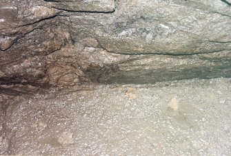 Detail of junction of slab floor of cistern and side walls showing bones and smears of charcoal.