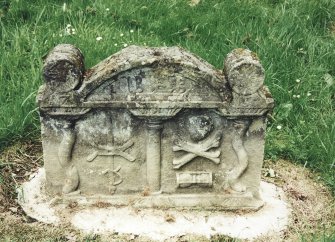 Tulliallan, Old Parish Church, burial ground.
General view of gravestone with twisted pilasters, curving top and incised cylinders. A mill rind pierced by a gauge(?) or rapier. Skull, crossed bones and hourglass appear below.