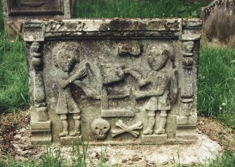 Tulliallan, Old Parish Church, burial ground.
General view of gravestone scene of two men with dividers, mallet, set square and chisel (?), with skull and crossed bones.
Insc: '17-9'