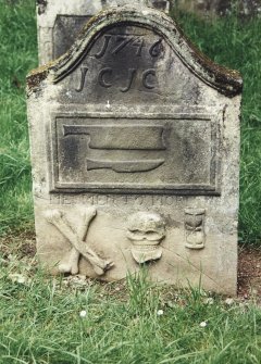 Tulliallan, Old Parish Church, burial ground.
General view of gravestone with cleaver and knife (the tools of a Flesher) within a frame, with crossed bones, grinning skull and hourglass below.
Insc: '1746. J.C.J.C' 'Memento Mori'.