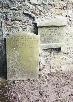 View of headstone and wall stone.