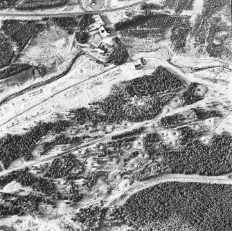 Wilsontown, oblique aerial view, taken from the ESE, showing the remains of workers' rows and buildings across the centre of the photograph, lime kilns in the centre left, and a large area of bell pits in the bottom half.