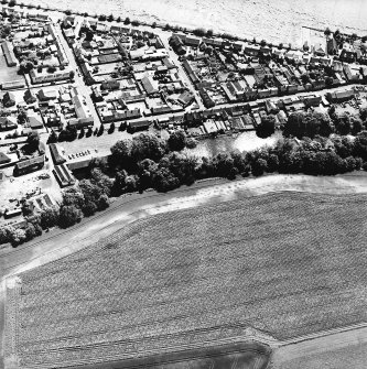 Friockheim, oblique aerial view, taken from the NNW, centred on the cropmarks of pit-alignments and pits. Friockheim is visible in the top half of the photograph.