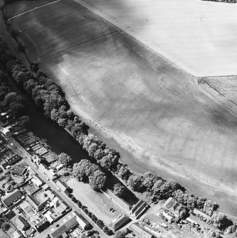 Milton and Friockheim, oblique aerial view, taken from the E, centred on the cropmarks of a pit-defined cursus, pit-alignments and pits. A possible unenclosed settlement is visible in the top left-hand corner of the photograph.
