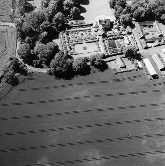 Pitmuies, oblique aerial view, taken from the W, centred on the cropmarks of a pit-circle and a possible unenclosed settlement. Pitmuies country house and garden are visible in the top half of the photograph.