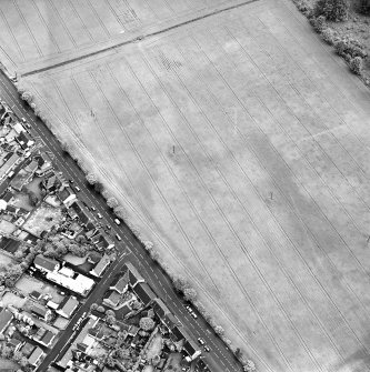 Oblique aerial view of Froickheim centred on the town, and the cropmarks of an enclosure, rig and linear cropmarks, taken from the WNW.