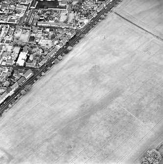 Oblique aerial view of Froickheim centred on the town, and the cropmarks of an enclosure, rig and linear cropmarks, taken from the SW.