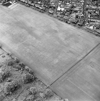 Oblique aerial view of Froickheim centred on the town, and the cropmarks of an enclosure, rig and linear cropmarks, taken from the SE.