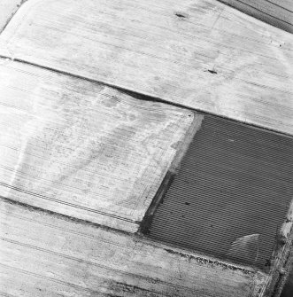 Oblique aerial view of the cropmarks fo the rig, possible enclosure and possible sunken floored building, looking SE.