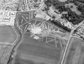 Oblique aerial view centred on the excavation of the enclosures, rig and other features, taken from the NW.