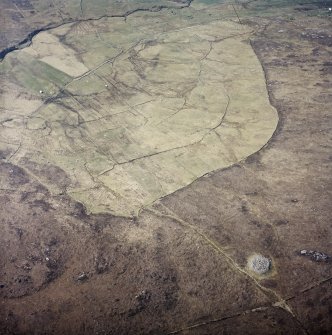 Oblique aerial view centred on the remains of the field system with the remains of the chambered cairn adjacent, taken from the NE.