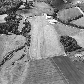 Oblique aerial view centred on the airfield and museum, taken from the E.