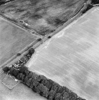 Oblique aerial view centred on the cropmarks of the ring-ditch with lodge adjacent, taken from the SW.