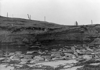 Photograph showing coastal erosion of structural features.