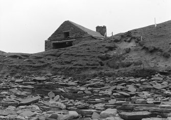 Photograph showing coastal erosion of structural features.