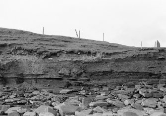 Photograph showing coastal erosion of structural features.