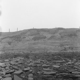 Photograph showing coastal erosion of structural features.