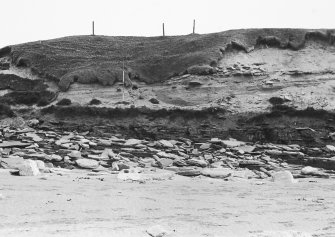 Photograph showing coastal erosion of structural features.