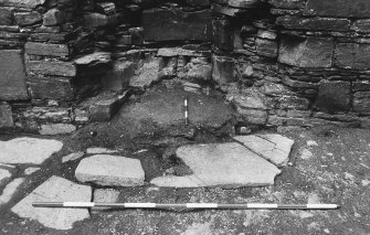 Excavation photograph : west range - room 1, unexcavated fireplace, from east.
