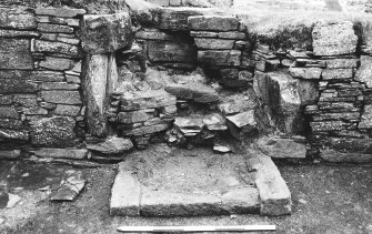 Excavation photograph : east range - room 1 fireplace partly excavated, from north.