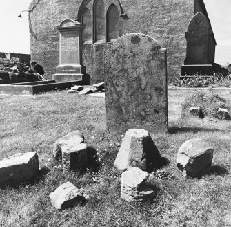 Excavated carved stones displayed in churchyard.