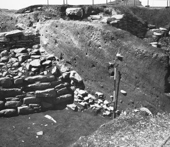 Publication Photograph: Mound covering broch courtyard and round house walls.