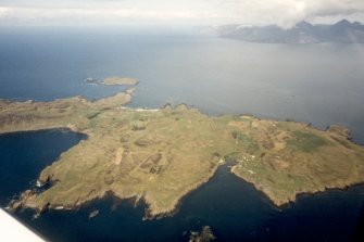 Oblique aerial view of the Isle of Muck, with Rum beyond, looking NW.