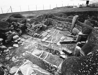 House 4; interior. Archaeological features marked on ground with tape.