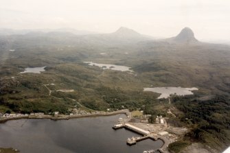 Oblique aerial view of the S part of Lochinver, Sutherland and surrounding Assynt area, looking SE.