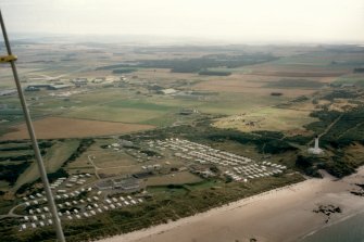 Oblique aerial view of Covesea Skerries Lighthouse and Silver Sands Caravan Park, near Lossiemouth, Moray, looking SW.